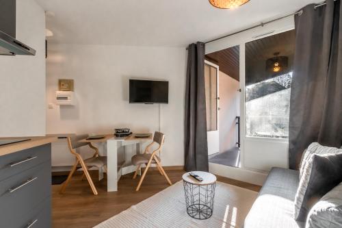 une cuisine et un salon avec une table et des chaises dans l'établissement Lachenal - Centre - Navette de ski - Balcon, à Chamonix-Mont-Blanc