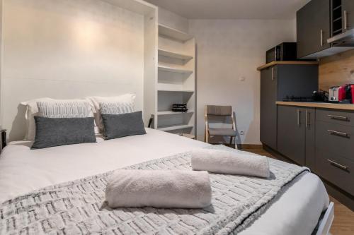 - une chambre avec un grand lit blanc et des oreillers gris dans l'établissement Lachenal - Centre - Navette de ski - Balcon, à Chamonix-Mont-Blanc