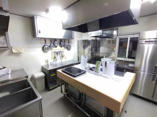 a kitchen with a counter top in a kitchen at Hakuba Norikura Wakaguri Guesthouse in Otari