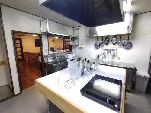 a kitchen with a sink and a counter top at Hakuba Norikura Wakaguri Guesthouse in Otari