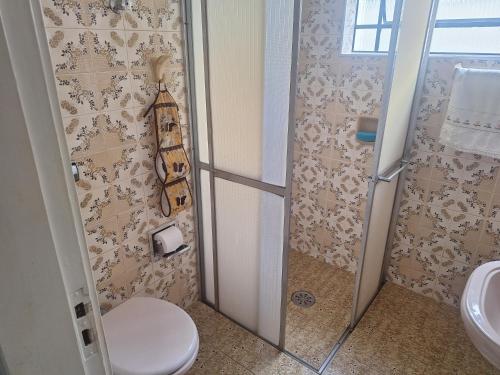 a bathroom with a shower with a toilet and a sink at Suítes em rua principal de Socorro-SP in Socorro