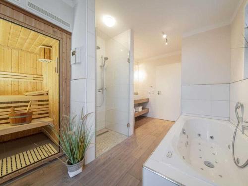 Un baño blanco con bañera y ducha. en Holiday home with 1 bedroom, en Rettin