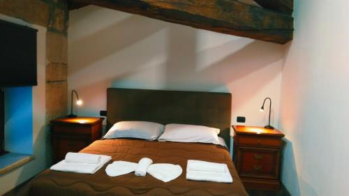 a bedroom with a bed with two towels on it at ATTIKO 53 Boutique Rooms in Verona