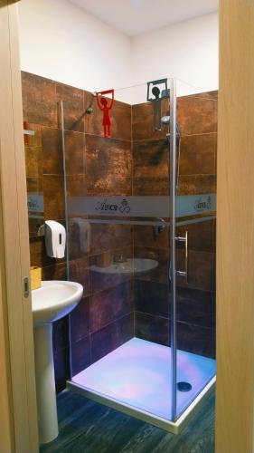 a shower with a glass door in a bathroom at ATTIKO 53 Boutique Rooms in Verona