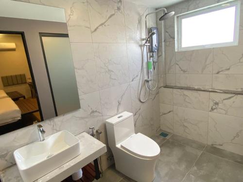 a bathroom with a toilet and a sink and a shower at ParkCity Inn in Sibu