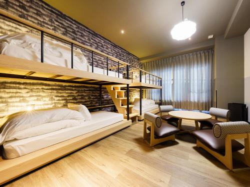 a bedroom with a bunk bed and a desk at Grandvrio Hotel Beppuwan Wakura - ROUTE INN HOTELS - in Beppu