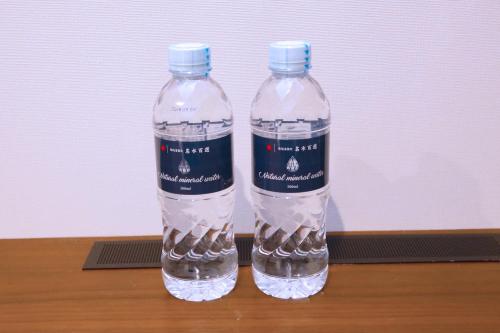 two bottles of water sitting on top of a table at goom Hotel Nakasu in Fukuoka