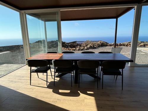 a dining room table and chairs with a view of the ocean at Villa Olimonte in Valverde