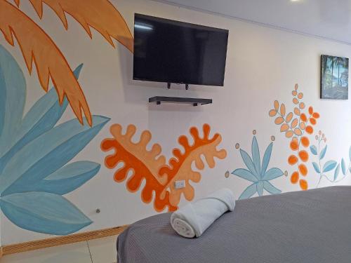 a bedroom with a wall mural with a tv on it at Jungla Urbana, BnB in Pavas