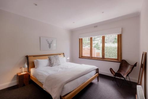 Un dormitorio con una cama, una silla y una ventana en Modern Home in Sandy Bay - Sleeps 8 Guests, en Sandy Bay