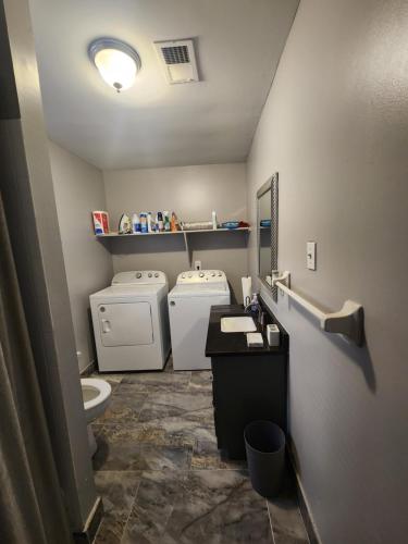 a bathroom with a toilet and a washer and dryer at Complete Dream in Memphis