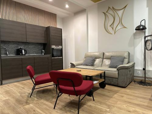 un salon avec un canapé, une table et des chaises dans l'établissement Serenity Résident Maison METZ GARE AV FOCH, à Metz