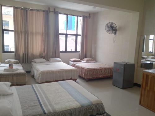 a hotel room with three beds and a window at Casa Nativa Iquitos in Iquitos