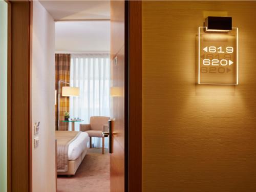 a door to a hotel room with a clock on the wall at Galaxy Iraklio Hotel in Heraklio Town
