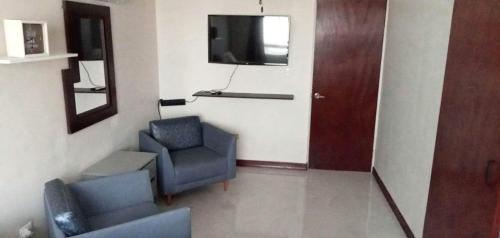 a waiting room with two chairs and a television at Descanso y diversión a 10 min puet. Anzalduas in Reynosa