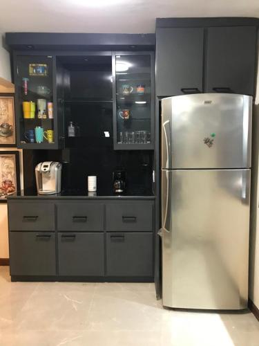 a kitchen with a stainless steel refrigerator and cabinets at Descanso y diversión a 10 min puet. Anzalduas in Reynosa