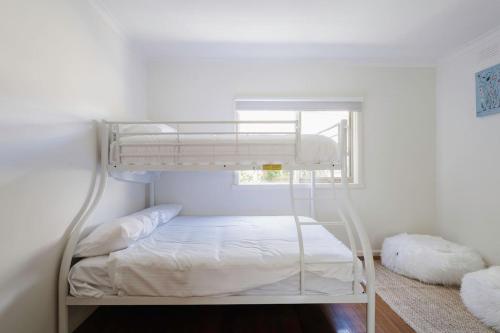 a bunk bed in a room with a window at Seaford Escape - Simple Comforts, Perfect Location in Seaford