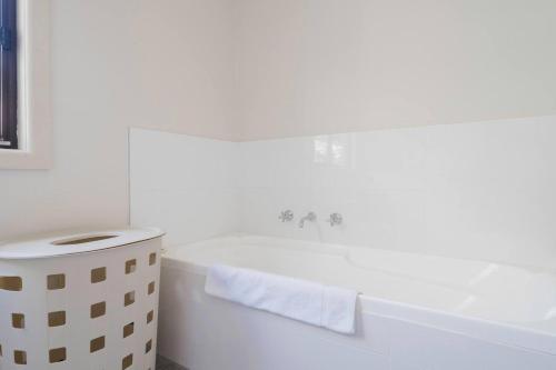 a white bathroom with a tub and a sink at Seaford Escape - Simple Comforts, Perfect Location in Seaford