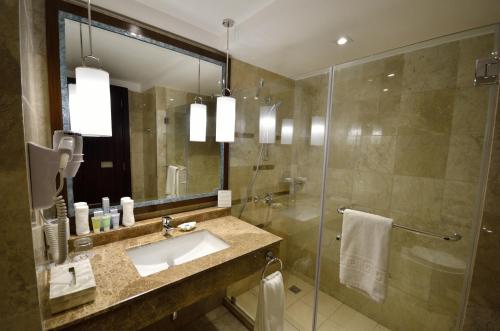 a bathroom with a sink and a glass shower at Henann Resort Alona Beach in Panglao