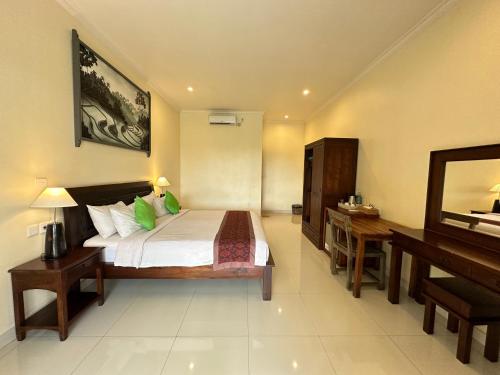 a bedroom with a bed and a desk and a piano at Brata Cottage Ubud in Ubud