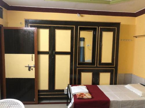 a room with a bed and a door with a mirror at Kodali Homestays in Bhadrāchalam