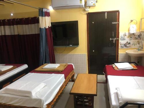 a small room with two beds and a sink at Kodali Homestays in Bhadrāchalam