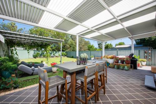 a patio with a table and chairs under a pergola at Georgie's Cottage - The Perfect Mudgee Getaway in Mudgee