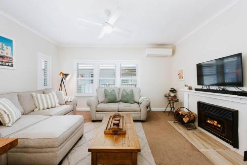 a living room with a couch and a fireplace at Georgie's Cottage - The Perfect Mudgee Getaway in Mudgee