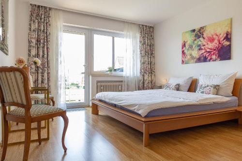 une chambre avec un lit, une chaise et une fenêtre dans l'établissement Silvaner-Laube Ferienwohnung Silvanerlaube A, à Meersburg