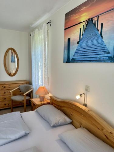 a bedroom with a bed with a painting on the wall at StrandGut in Uhldingen-Mühlhofen