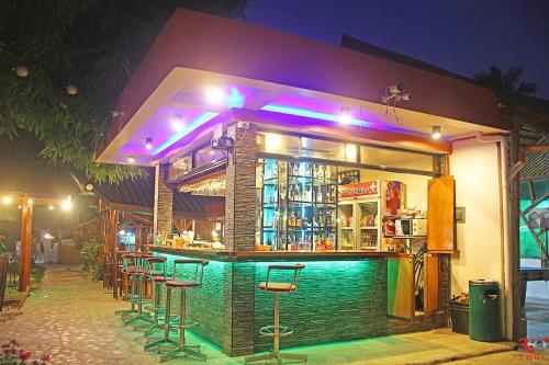 a bar with stools in front of a building at night at Hotel Oasis Port Barton in San Vicente