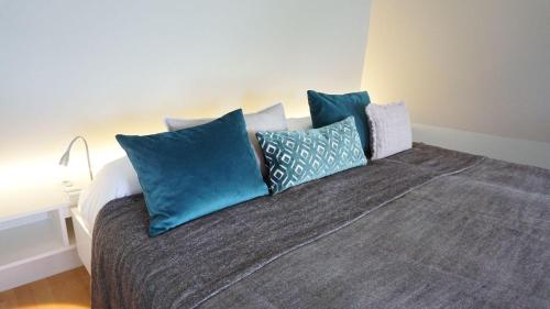 Una cama con almohadas azules encima. en Ferienwohnung Weitsicht, en Meersburg
