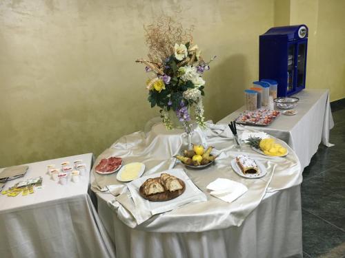 a table with plates of food and a vase of flowers at Hotel Villa d'Evoli in Castropignano