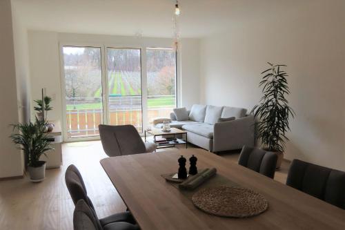 una sala de estar con una mesa y un sofá en Mariahof Mariahof 1, en Uhldingen-Mühlhofen