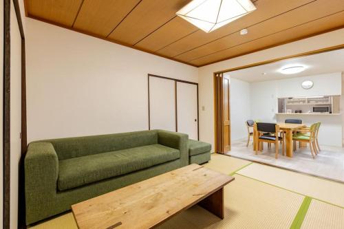 a living room with a green couch and a table at ドリームホテル大博 in Fukuoka