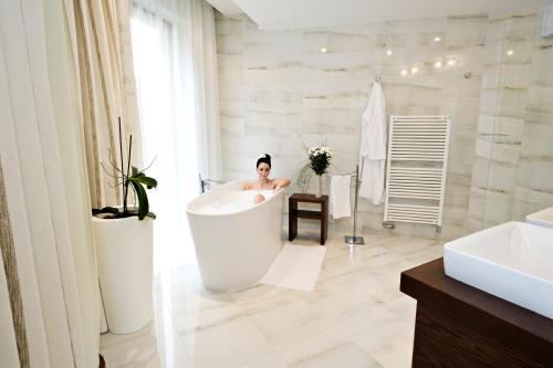 a woman in a bath tub in a bathroom at Hotel Zochova Chata - Adult friendly in Modra