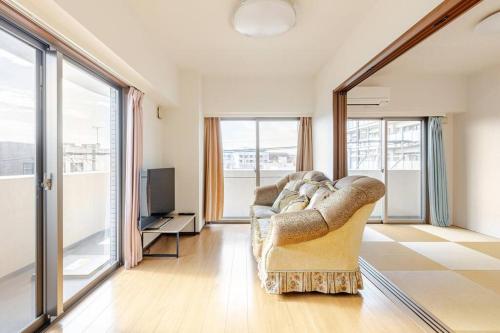 a living room with a couch and a television at Jintai House501 in Fukuoka