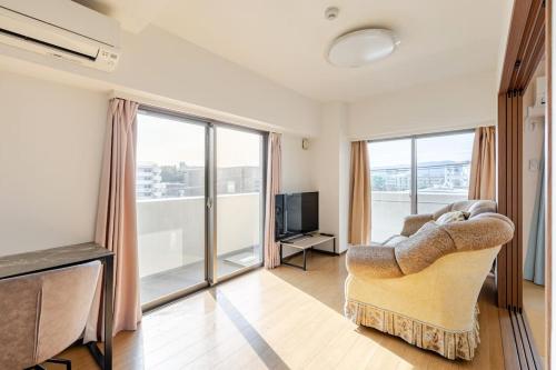a living room with a couch and a television at Jintai House501 in Fukuoka