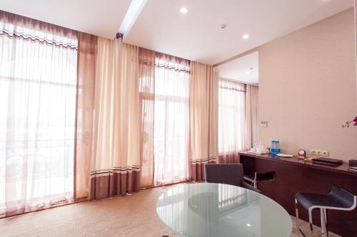 a room with a glass table and some windows at Park Hotel Bishkek in Bishkek