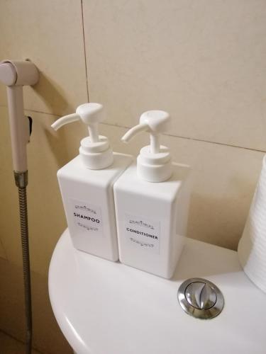 two white bottles sitting on top of a toilet at JD Homestays CDO in Cagayan de Oro