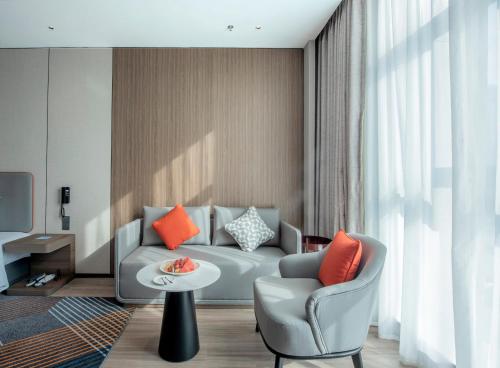a living room with a couch and a table at Holiday Inn Express Yinchuan Lanxi Valley Plaza by IHG in Yinchuan