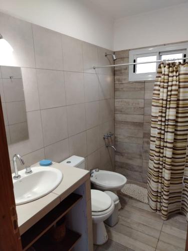 a bathroom with a sink and a toilet and a shower at Cabaña de campo La Tabanerina in Salto de las Rosas