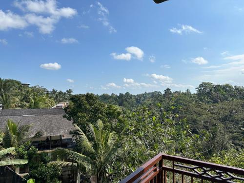 a view of the jungle from the balcony of a house at Brata Cottage Ubud in Ubud