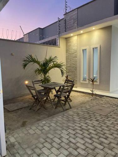 a patio with a table and chairs in front of a house at Casa Miguel Arcanjo in Cascavel