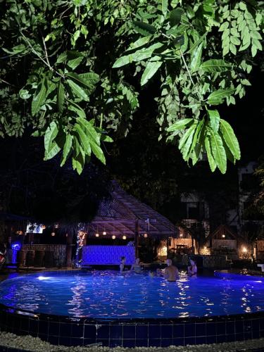 a swimming pool at night with blue lights at Sundaras Resort LTD in Dambulla