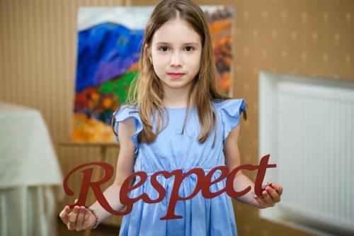 a little girl holding a sign that says respect at СПА-Готель "RESPECT" in Skhidnitsa