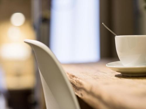 a table with a cup and a bowl on it at Webers "alte Backstube" in Friedrichshafen