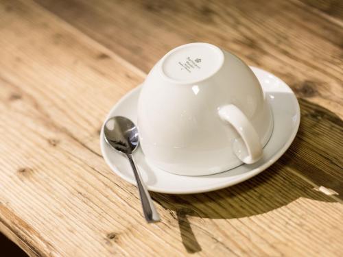 a cup and spoon on a plate on a table at Webers "alte Backstube" in Friedrichshafen