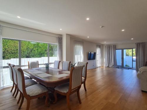 a dining room with a table and chairs and a large window at Dream House 3 in Auckland
