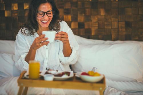 a woman sitting on a bed looking at her cell phone at Jungle Vista Boutique Hotel in Manuel Antonio